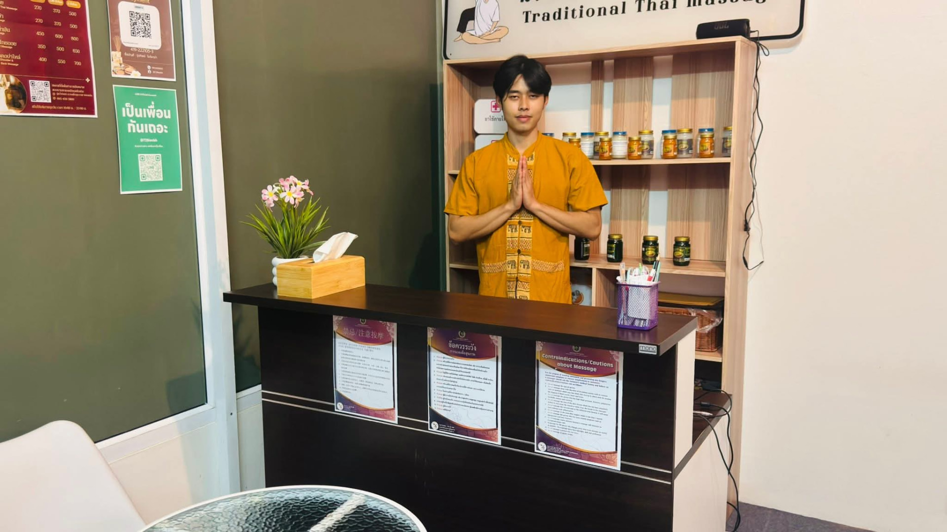 พนักงานต้อนรับร้านน้ำทิพย์ยกมือไหว้ที่เคาน์เตอร์ต้อนรับ