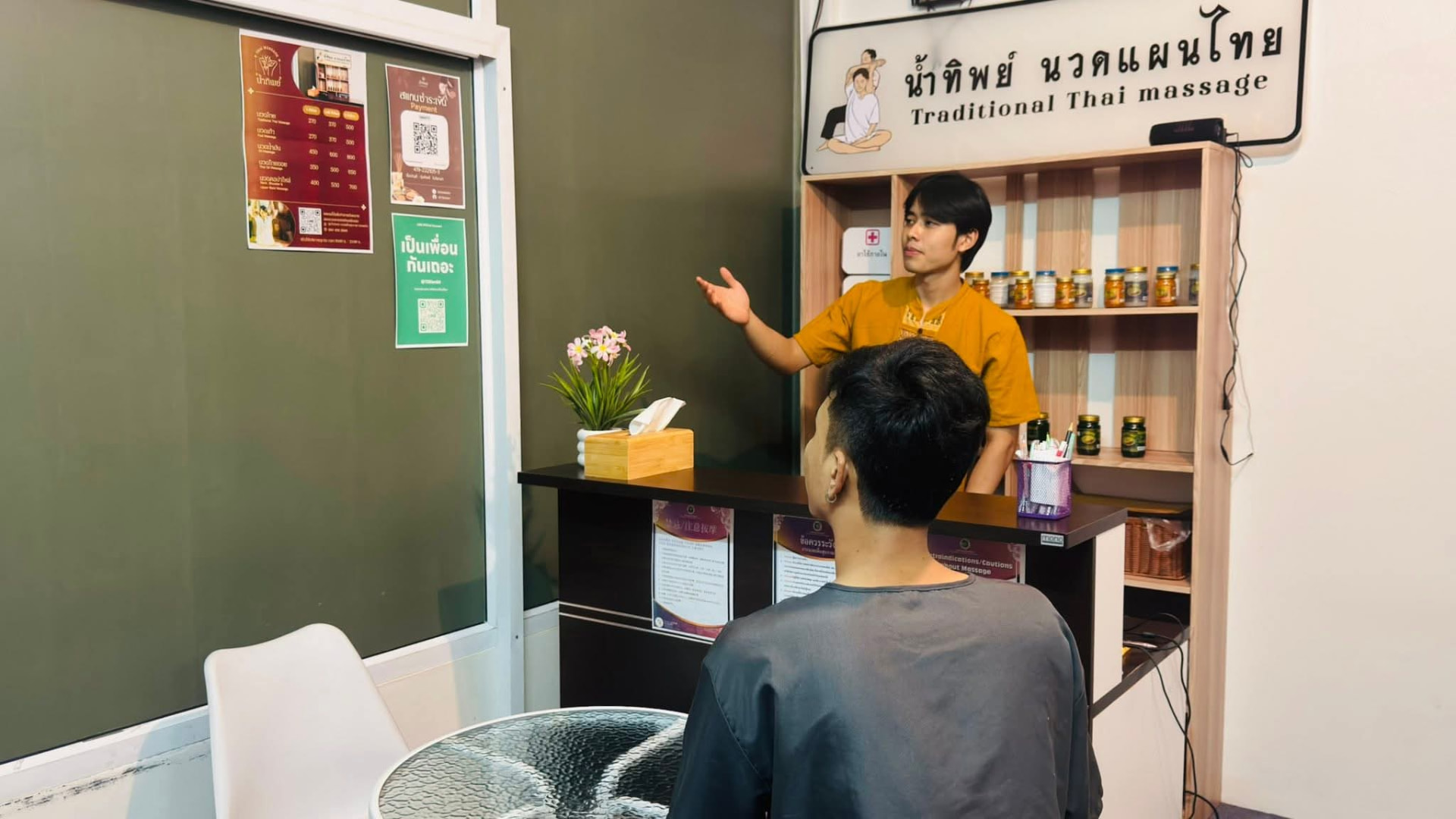 พนักงานร้านน้ำทิพย์แนะนำบริการให้ลูกค้าที่เคาน์เตอร์